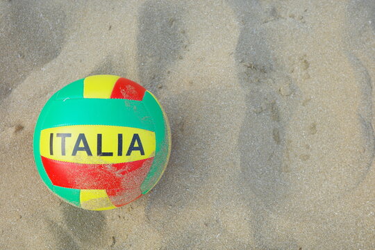 Bright colorful Italia beach ball on soft sandy beach from a top-down view
