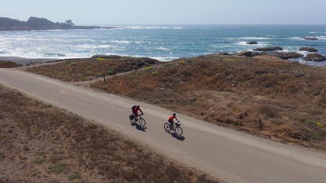 Mature man and woman bike on the Coastal Trail in Fort Bragg, enjoying the stunning views of the Pacific ocean near Mendocino