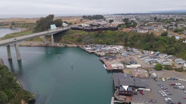 Aerial views show the Noyo Harbor Bridge and River along with Fort Bragg California and local seafood restaurants and markets.