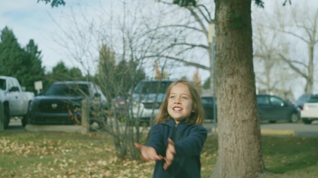 Boy laughing and running through an autumn park near trees