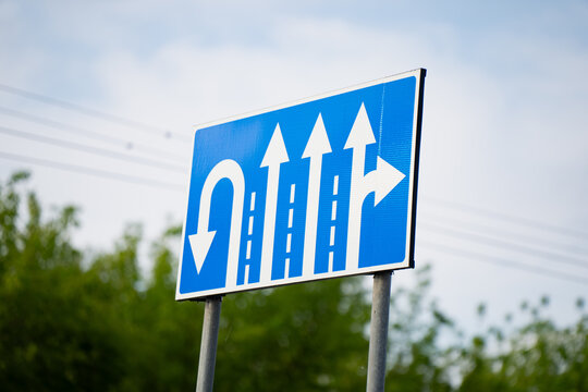 Multi lane road direction traffic sign with white arrows symbolizing decision choices strategic vision navigation and corporate guidance