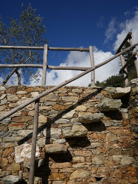 Stone wall with a wooden railing and a stone staircase