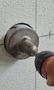 Vertical close-up video of drilling an aerated concrete wall with a core drill for electrical installation.