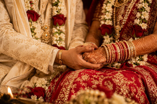 Indian Bride and Groom Holding Hands During Traditional Hindu Wedding Ceremony