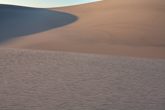 Beautiful abstract sand dunes landscape with sharp shadows and wind ripples