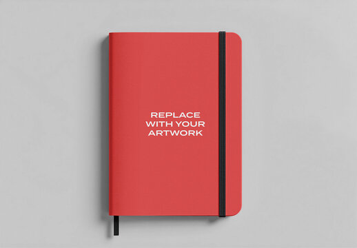 Notebook mockup with black elastic band displayed on a gray surface in vertical orientation, minimalist stationery branding presentation, template for artwork or design placement flat lay