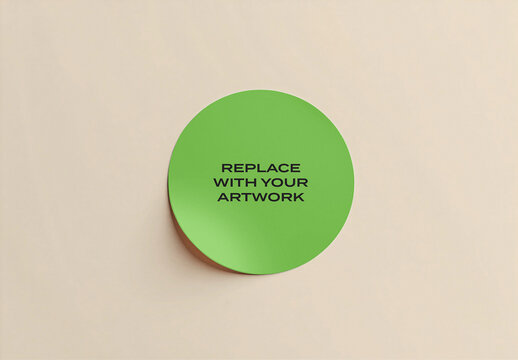 Circular sticker mockup on a neutral beige surface with text placeholder for artwork replacement, minimalist design template branding presentation, adhesive label display desk or wall