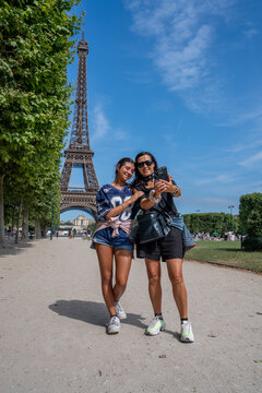 Mother and daughter in front of Eiffel Tower on sunny summer day in Paris