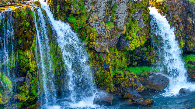 Panoramic summer landscape of Kirkjufell Iceland featuring cascading waterfalls and mountain scenery