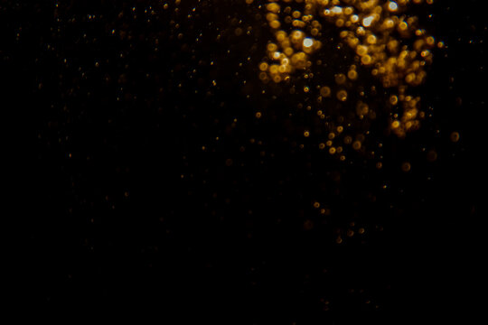 Blurred photo with golden dots visible glittering, shining brightly look and feel luxurious Suitable for use as a wallpaper