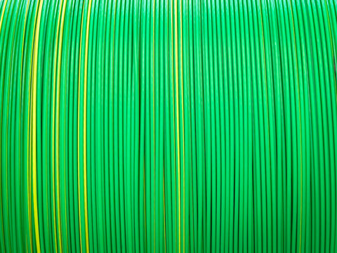 Vivid green and yellow plastic coated cables tightly coiled, showcasing a symmetrical and colorful pattern