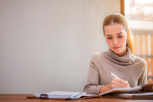 pretty young woman studying alone at a library