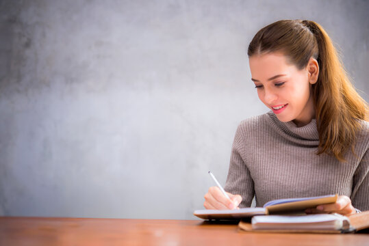 pretty young woman studying alone at a library