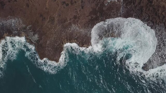 Aerial top down view of the Hawaiian shore with powerful waves breaking over the reef
