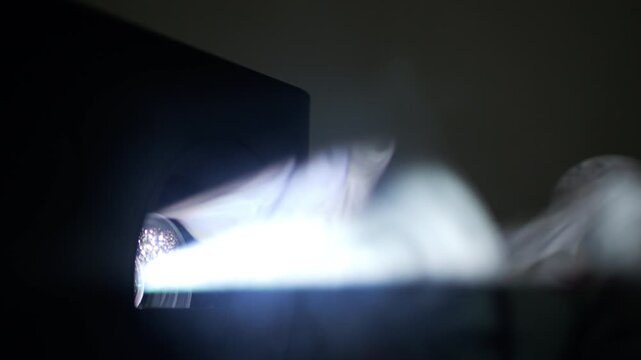 Vaporizer emitting smoke rings and puffs of steam in the dark