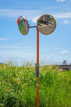 Urban landscape and blue sky reflected in a traffic mirror in Tokushima, Japan