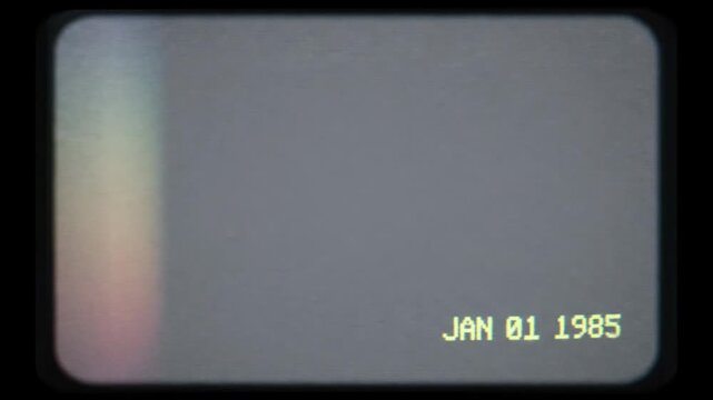 Vintage 1985 vhs video tape frame with date stamp, retro analog film grain, light leak, and scan lines on a dark grey background