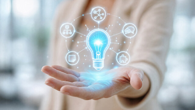 A hand holding a glowing lightbulb with technology icons orbiting it, symbolizing innovation and new ideas
