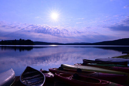Sunrise over canoes on the beach at Lake of Two Rivers Campground in Algonquin Provincial Park Ontario Canada 