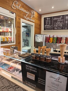 Como, Italy - June 24, 2026: Italian Gelateria Lariana Shop Counter with Waffle Cones Slush Machines and Ice Cream Menu Board in Como Italy