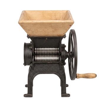Vintage cast iron and wood fruit crusher with a large turning wheel for processing produce