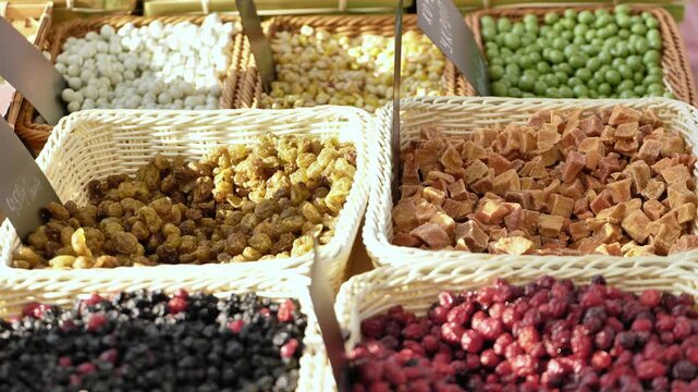 Assortment of dried fruits and berries in baskets at a market stall
