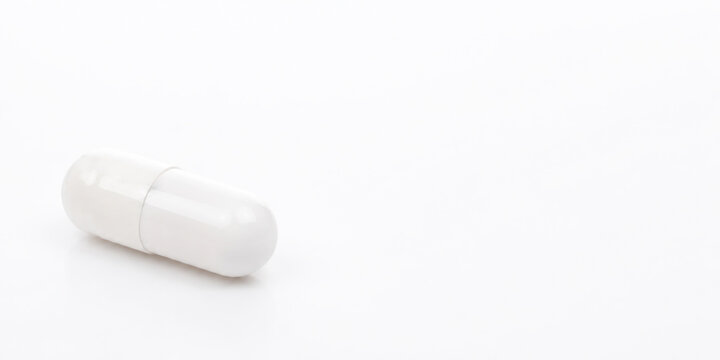White Capsule Pill on White Background with Copy Space