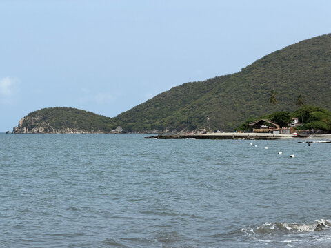 Vista panor&aacute;mica de Playa Pozos Colorados en Santa Marta, Colombia, con aguas azules y colinas verdes