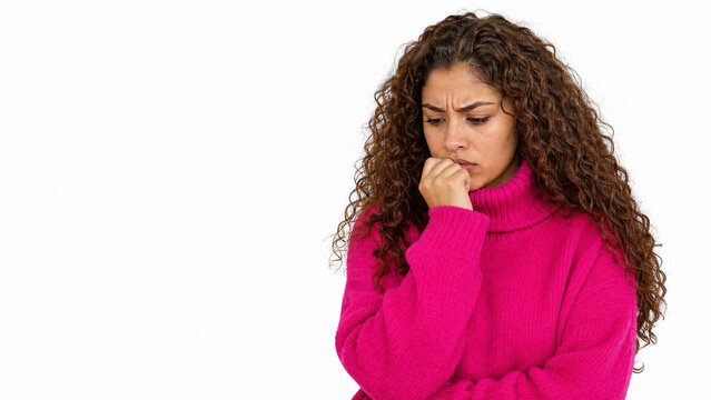 A young woman with curly hair, wearing a pink turtleneck sweater, looks down with a worried expression, biting her nails.
