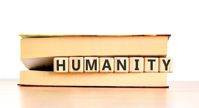 Humanity word symbol. Concept word Humanity on beautiful wooden blocks in beautiful book. Beautiful wooden table white background. Business support help humanity word concept. Copy space.