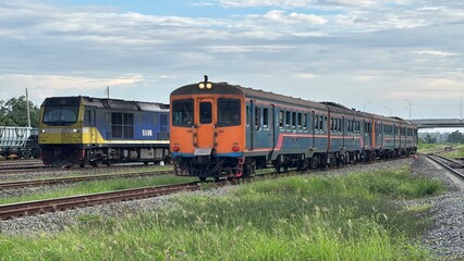Passenger Train and Freight Locomotive Engine Running Parallel on Railway Tracks in Thailand © Kauncheewa
