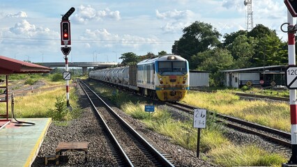 Train Carrying Cement Tankers Passing Signal Light at Railway Station in Thailand © Kauncheewa