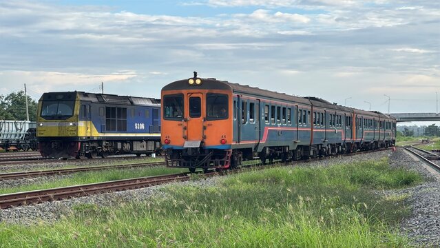 Passenger Train and Freight Locomotive Engine Running Parallel on Railway Tracks in Thailand