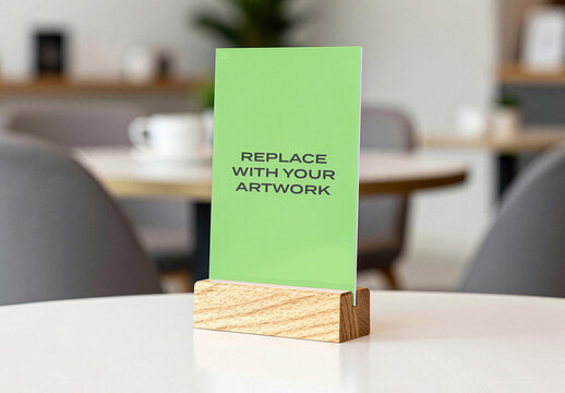Vertical poster mockup displayed on a wooden stand placed white table in cafe interior with blurred background, Template, design, presentation, blank