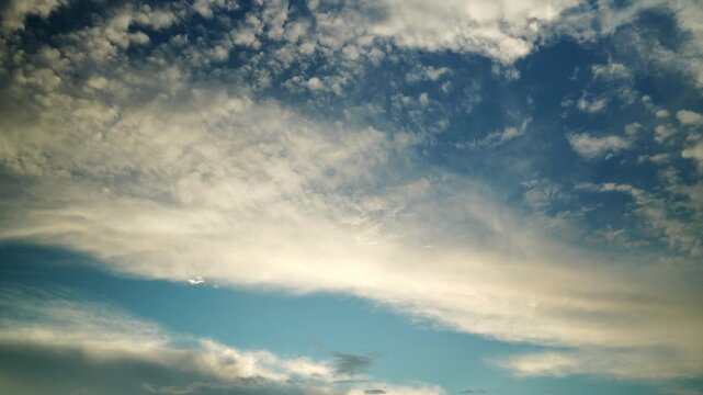 A celestial chronicle of a blue sky with gently floating fluffy clouds. Extraordinary natural beauty.