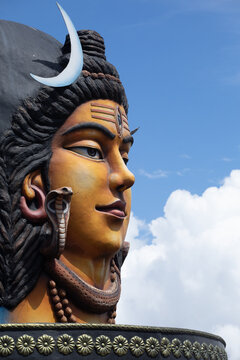 View of the Lord Shiva statue in Pumdikot featuring intricate details like the crescent moon and a snake, set against a clear blue sky in Pokhara, Gandaki Province, Nepal.