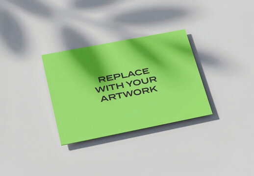 Rectangular business card mockup presented on a light gray surface with soft shadows and natural lighting, realistic stationery branding presentation, template for graphic design print