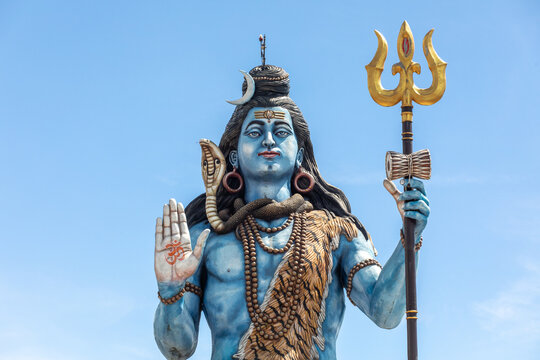 View of the large Lord Shiva statue featuring blue skin, a trident, and a cobra, set against a clear blue sky in Pokhara, Gandaki Province, Nepal.