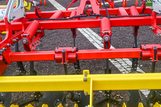Red agricultural plow mechanism on gravel The Concept of farming and heavy machinery