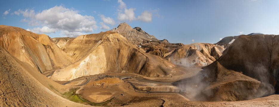 View of the geothermal landscape of Kerlingarfjoll with rhyolite mountains, rising steam vents, and rugged terrain in Hrunamannahreppur, Iceland.