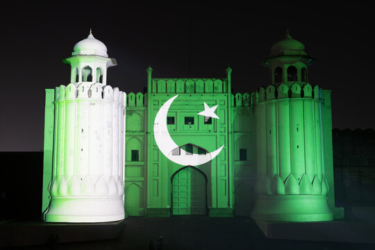 View of the Aalamgiri Gate at Lahore Fort illuminated with green light and a white crescent and star projection for Independence Day in Lahore, Punjab, Pakistan.