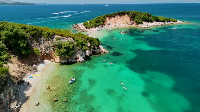 Woman on sup board in Ksamil near Twin Islands, Ionian Sea, Saranda, Albania. Stand up paddle board woman paddle boarding. Aerial panoramic drone view from above, top view from drone. Mediterranean se