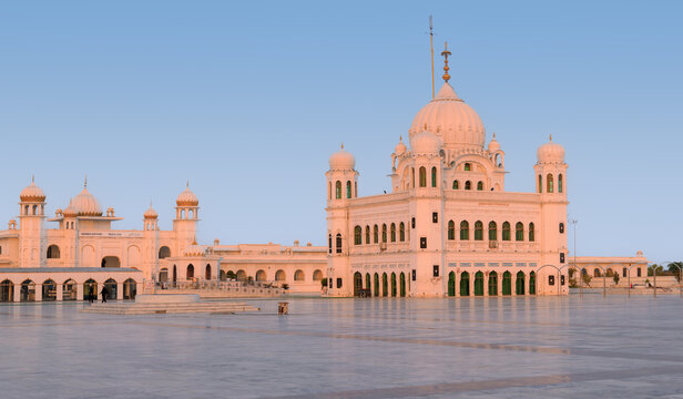 View of Gurdwara Darbar Sahib Kartarpur with its white domes and arches under a clear sky in Kartarpur, Punjab, Pakistan.
