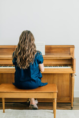 Woman playing sheet music on a piano © Jenisse