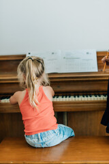 young child sitting and playing the piano © Jenisse