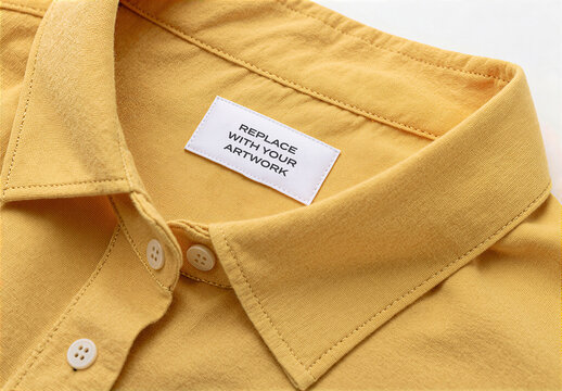 Button-up shirt collar mockup with label tag that reads REPLACE YOUR ARTWORK, close-up view of garment interior, clothing branding presentation, template for graphic design