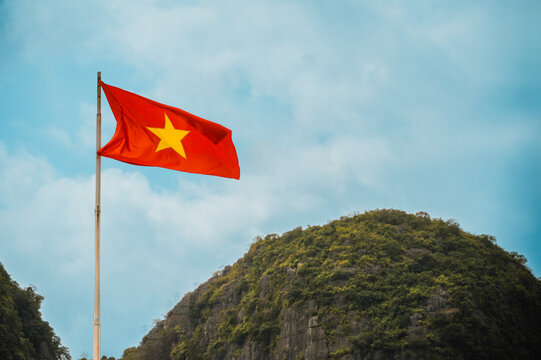 Vietnamese flag above Ninh Binh limestone karst landscape