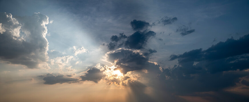 Panoramic Sunset Sky with Dramatic Sun Rays Piercing Storm Clouds.
