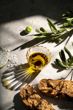 Olive oil with bread and olive branch in sunlight