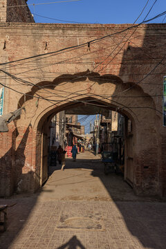 View of the historic Sathgara gateway built by Mir Chakar Rind Baloch with brick masonry and overhead power lines in Satghara, Punjab, Pakistan.